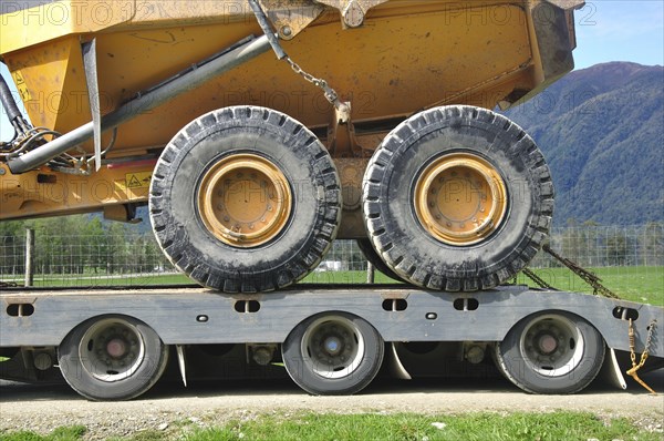 Detail of the wheels of a 30 ton dump truck loaded on a semi-trailer