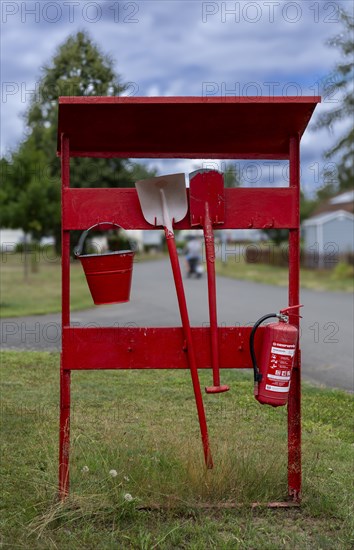 Red fire extinguishing point with fire extinguisher, shovel, spade and bucket at a campsite on Lake