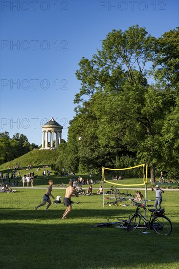People playing volleyball in a meadow in the English Garden, people enjoying the summer day in the