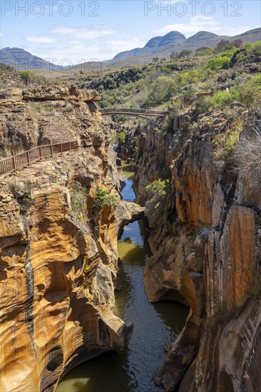 Bridge over a canyon with steep orange-coloured cliffs and the Blyde River, Bourke's Luck Potholes,