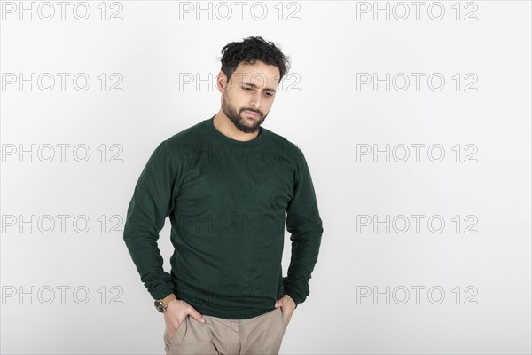 Portrait of man with depressed attitude looking down and hands in pockets