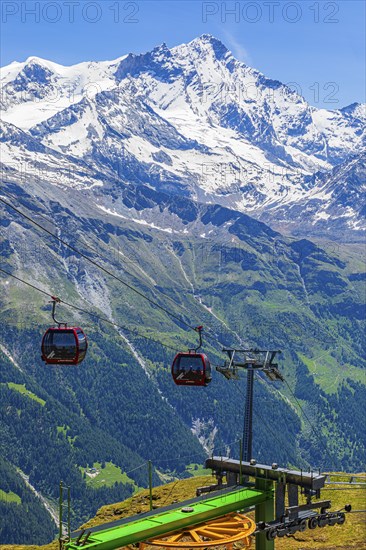 Gondolas of the cable car from Zinal to Corne de Sorebois, behind the snow-covered Weisshorn, Val