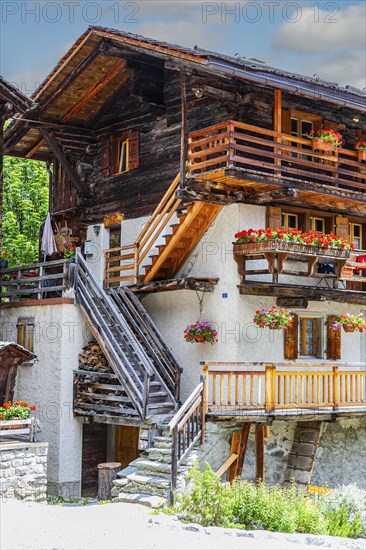Wooden outside steps on an old house, flower boxes in front of windows and balconies, historic