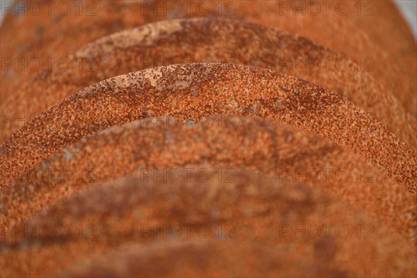 Grunge background of rusted plough shares on an old cultivator