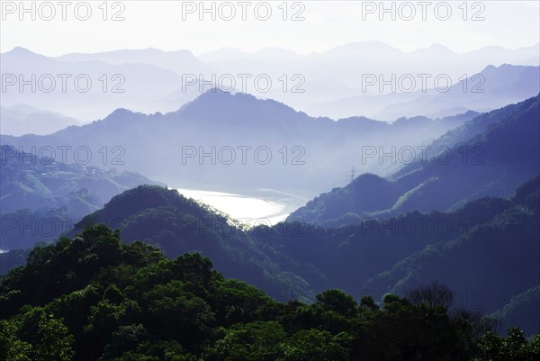 A misty mountain range with layered hills and valleys bathed in tranquil morning light, Shimen