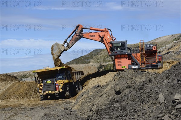 WESTPORT, NEW ZEALAND, MARCH 11, 2015: 190 ton digger loads rock from a layer of overburden at open
