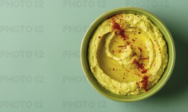 Avocado and hummus dip on a light green background AI generated