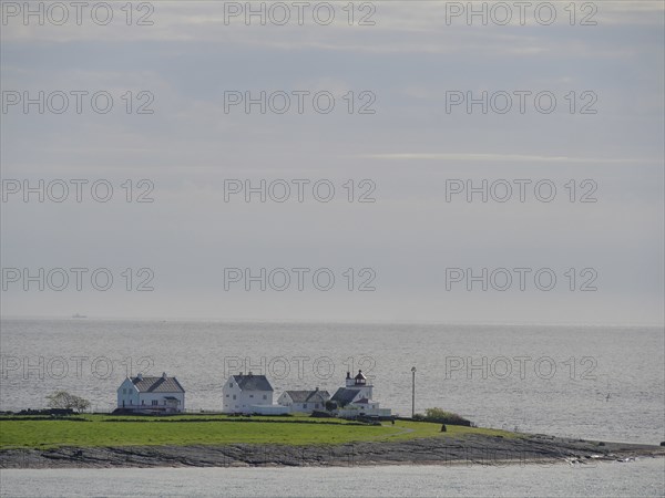 An island with few houses surrounded by the sea under a cloudy sky, Stavanger, Norway, Europe
