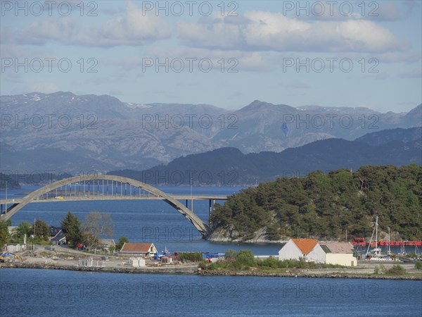 Bridge over the sea, surrounded by mountains, sky and clouds and houses on the shore, Stavanger,