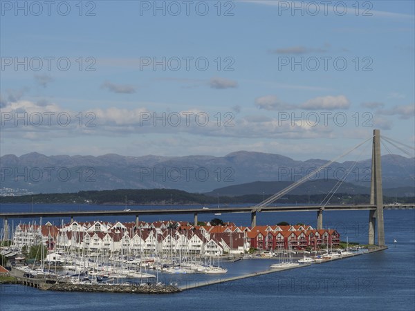 Marina with bridge spanning the sea and houses with red roofs, Stavanger, Norway, Europe