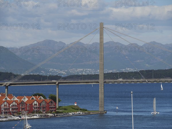Bridge over the sea with mountains and houses with red roofs in the foreground, Stavanger, Norway,