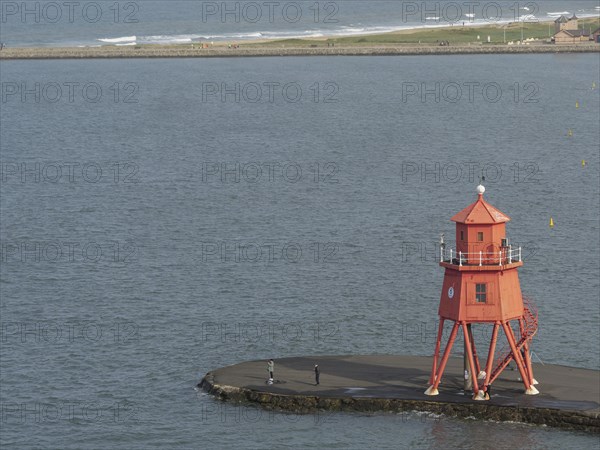 Red lighthouse on a pier, on a calm day with a wide sea view, Newcastle, England, Great Britain