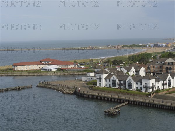 Stretch of coastline with several modern houses and views of the tranquil seascape, Newcastle,