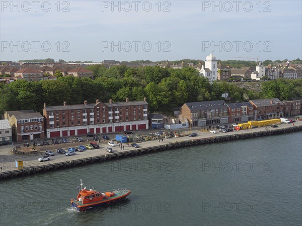 A coastal town with buildings and a boat in the harbour, Newcastle, England, Great Britain