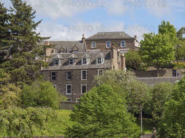 Historic buildings surrounded by green trees and vegetation on a sunny day in spring, inverness,