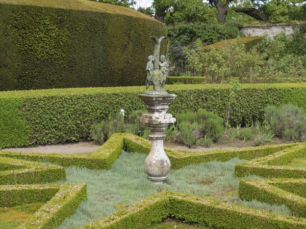 A garden landscape with manicured hedges, symmetrical shapes and a central sculpture, inverness,