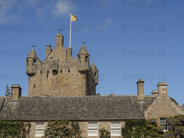 Historic stone castle with towers and a flag under a clear blue sky, inverness, Scotland, United
