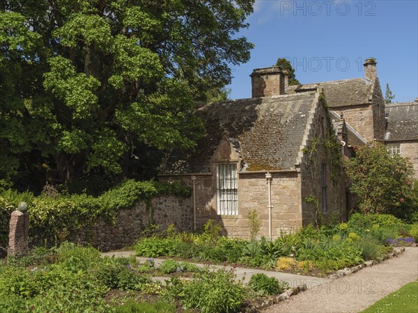 Small stone house in garden with trees and sunny weather, inverness, Scotland, United Kingdom,