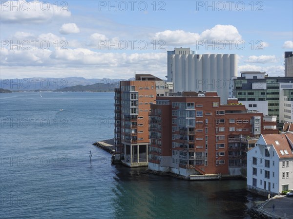 Modern residential building on the waterfront with blue sky and clouds in the background,