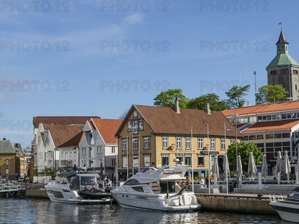 A city view by the water with yachts in the foreground and a sunny atmosphere, Stavanger, Norway,