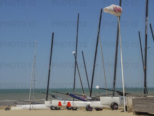 Several sailing boats on the beach, the sea and a clear blue sky in the background, de haan,