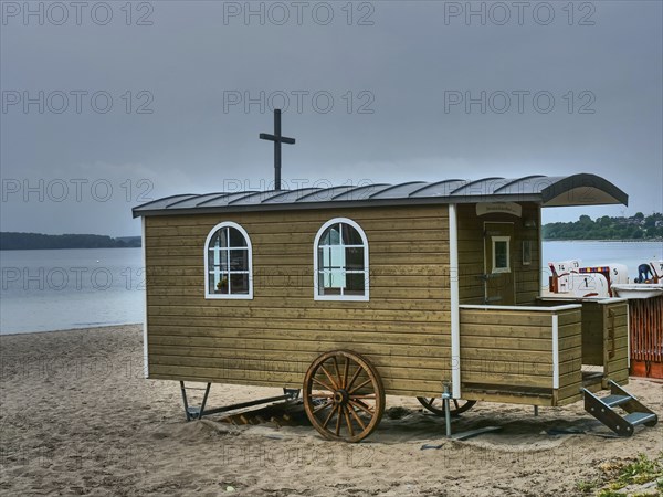 Wooden wagon on a gloomy beach, close to the water, surrounded by beach chairs, Eckernförde,