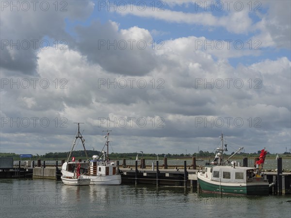 Two boats at a jetty under a partly cloudy sky, Maasholm, Schleswig-Holstein, Germany, Europe