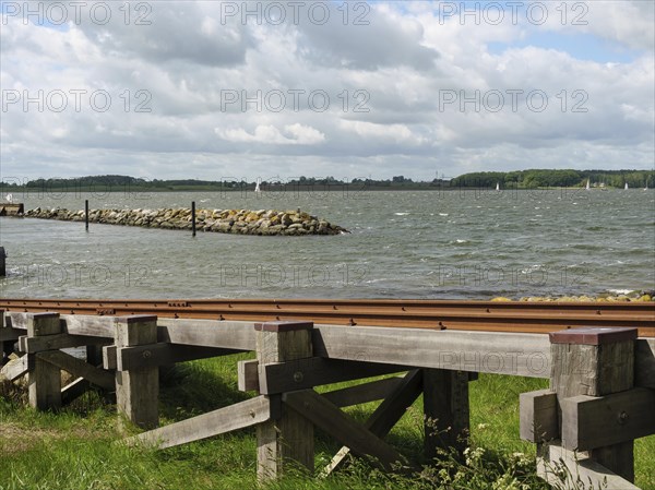 View of a wooden jetty on the lake under a partly cloudy sky, Maasholm, Schleswig-Holstein,