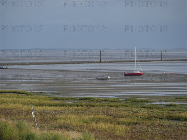 Wide mudflats with boats in the shallow water and a calm, peaceful feeling, juist, east frisia,