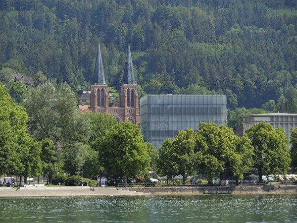 Two church towers and a modern building in a green, wooded setting by the lake, Lindau, Lake