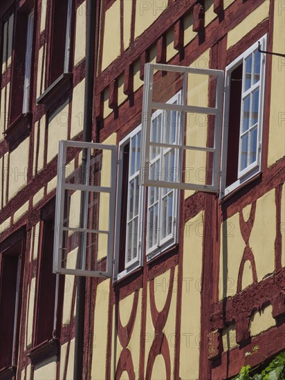 Close-up of a half-timbered house with open windows and visible details in the sunlight, Meersburg,
