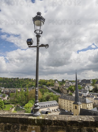 Urban landscape with modern elements, clouds in the sky and a historic lantern, Luxembourg City,