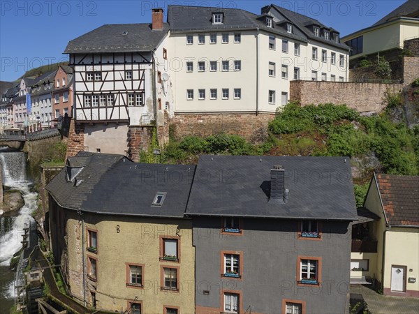 Historic buildings and half-timbered house next to a river in a picturesque town view, Saarburg,