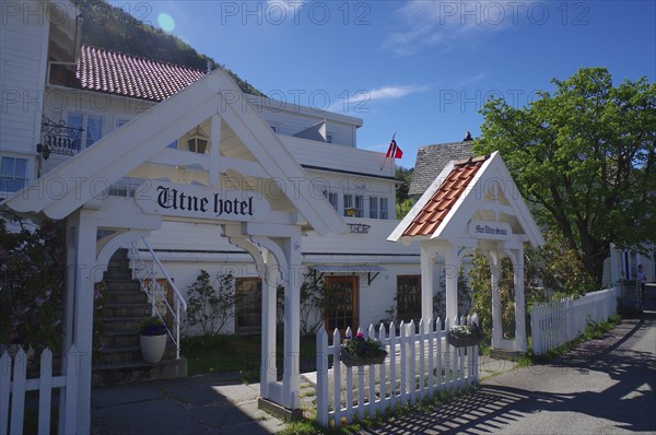 Historic wooden hotel with white facades, red roofs, flowers and blue sky, Edvard Grieg, Utne,