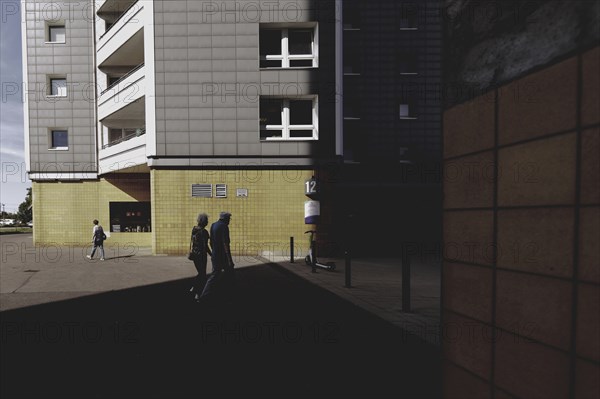 Two elderly people are silhouetted in front of a block of flats in Marzahn, taken in Berlin,