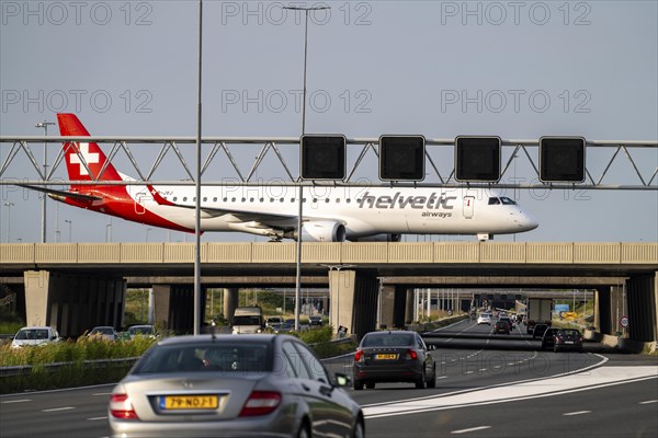 Amsterdam Schiphol Airport, Helvetic Airways Embraer ERJ-195, aircraft on the taxiway, bridge over