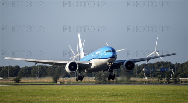 KLM aircraft landing at Amsterdam Schiphol Airport, Polderbaan, 18R/36L, wind farm in the
