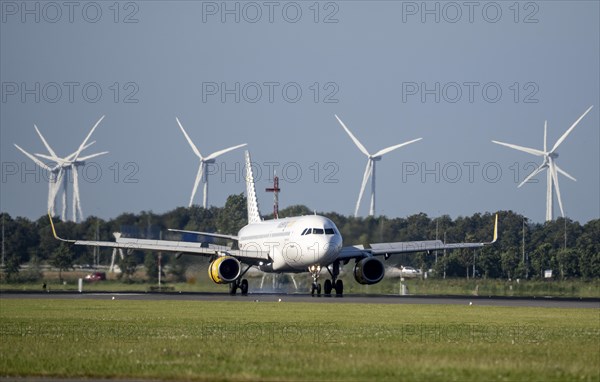 Vueling.com aircraft landing at Amsterdam Schiphol Airport, Polderbaan, 18R/36L, wind farm in the