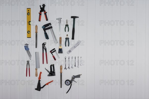 Tools on the wall, file, rasp, stapler, blind rivet pliers, spirit level, hammer, metre rule,