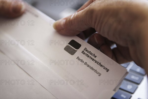 An elderly woman opens a letter from Deutsche Rentenversicherung. Berlin, 05.08.2024