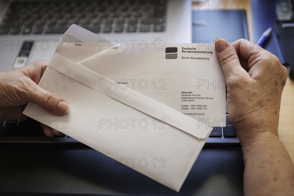 An elderly woman opens a letter from Deutsche Rentenversicherung. Berlin, 05.08.2024