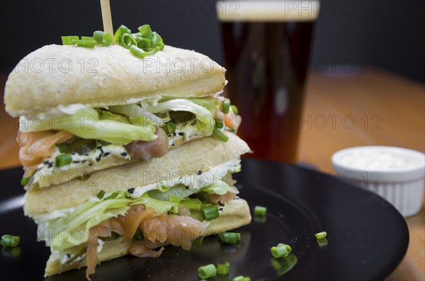 Delicious salmon sandwich close-up and glass of beer