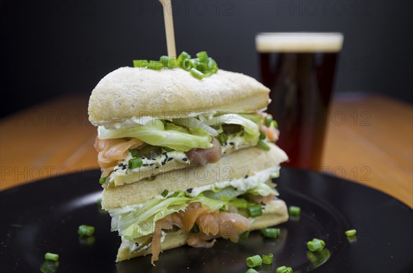 Delicious salmon sandwich close-up and glass of beer