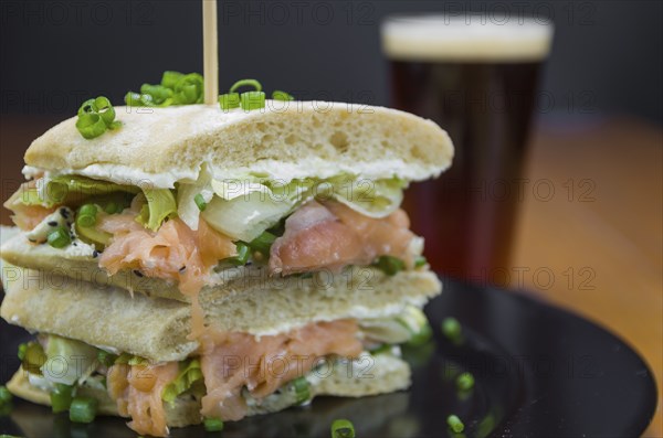 Delicious salmon sandwich close-up and glass of beer