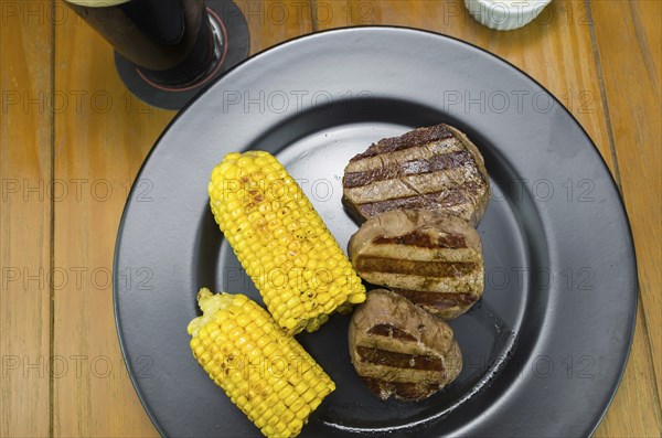 Delicious filet mignon close-up with roasted corn and glass of beer
