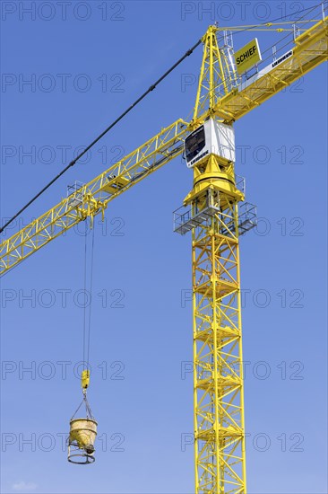 Construction crane with concrete bucket, concrete silo, crane bucket