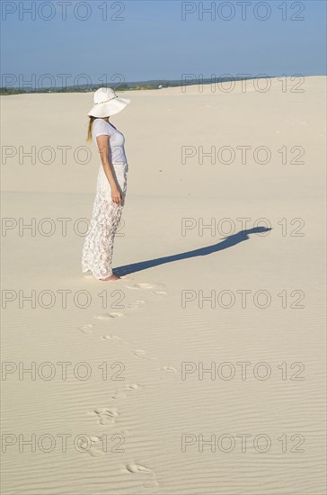 Young woman walking in the dunes, desert