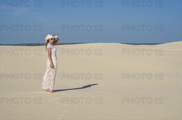 Young woman walking in the dunes, desert