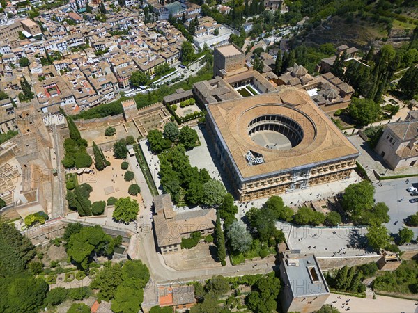 Historic city with striking round building, surrounded by trees and streets, bird's eye view in