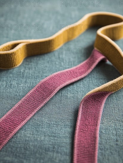 Close-up of pink and yellow ribbons on a green background, AI generated